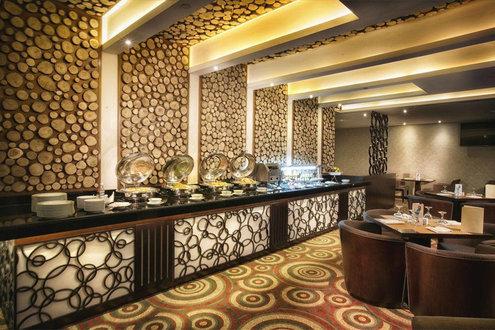 Ghaya Grand Hotel restaurant with sliced-log accent wall