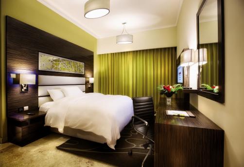Hotel apartment bedroom with olive curtains